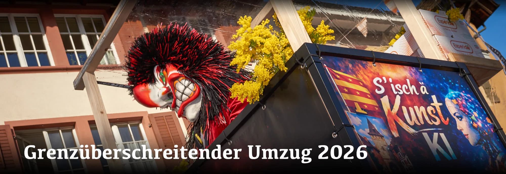 Rote Fasnachtsfigur an Fassade, Schild S'isch ä Kunst